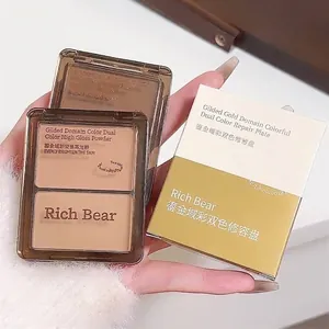 Gros plan de la palette de contouring et d'highlighter bicolore Rich Bear en main