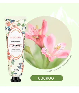 Macro detail of Meidian floral hand cream tube featuring Cuckoo extract and pink lilies.