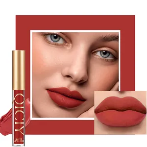 Close-up of matte red lip gloss on model lips with product bottle and swatch detail.