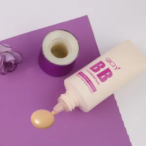 Detail shot of QICIY BB foundation cream tube and texture swatch on a purple surface