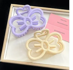 Détail de jolies pinces à cheveux en forme de cœur, couleurs lavande et crème mat
