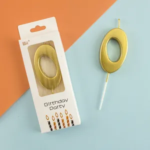 Premium golden number 0 birthday candle in retail packaging on a split color background