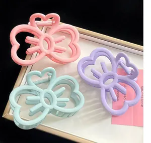 Vue détaillée de trois pinces à cheveux en forme de cœur rose violet et vert pastel