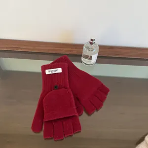 Close-up of red wool convertible fingerless gloves with flap and MICHEYRABBIT label.