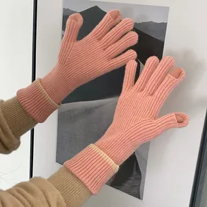 Close-up detail of coral knitted gloves with two-finger cutouts for easy touchscreen use