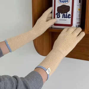 Warm knitted winter gloves in beige with blue trim and cute label detail for women.