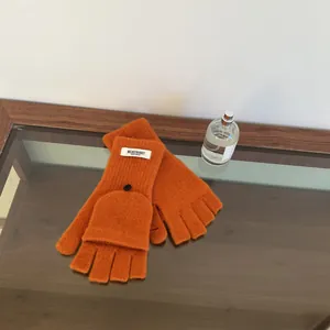 Detailed shot of orange 100% wool flip-top gloves with functional fingerless design