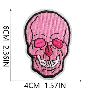Detail of a pink skull embroidery patch showing dimensions 6x4cm for sewing projects.