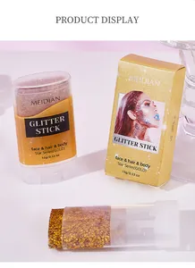 Close-up of MEIDIAN gold glitter stick for face hair and body in packaging box