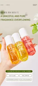 Tre piccoli flaconi di profumo floreale ADMD tenuti in mano su sfondo naturale