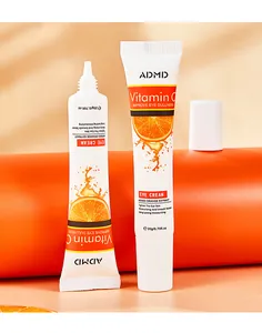 Macro shot of ADMD Vitamin C eye cream tubes with orange extract and moisturizing texture.