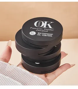 Close-up of four black matte waterproof oil control powder compacts held in hand