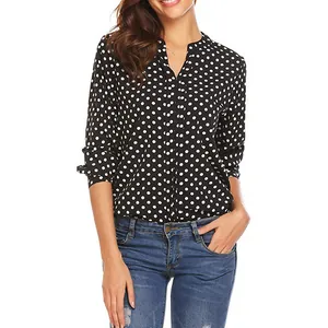 Detailed view of women's black polka dot V-neck blouse with roll-up sleeves.