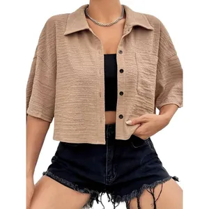 Women's solid color cropped button-up shirt with short sleeves and pocket detail.