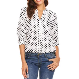 Close-up of a white loose-fitting blouse with black polka dot print and a deep V-neckline