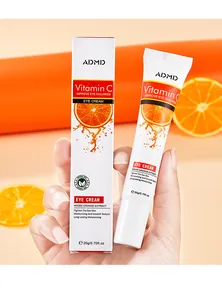 Close-up of ADMD Vitamin C eye cream tube and packaging box with fresh orange slices