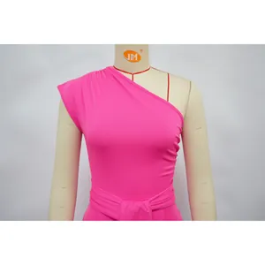 Close-up detail of a bright pink one-shoulder dress featuring an elegant waist-tie