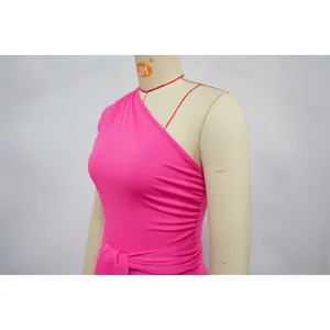Close-up detail of a vibrant pink one-shoulder summer dress with waist tie design