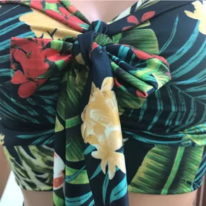 Close-up detail of a vibrant tropical floral print bikini top featuring a front tie knot