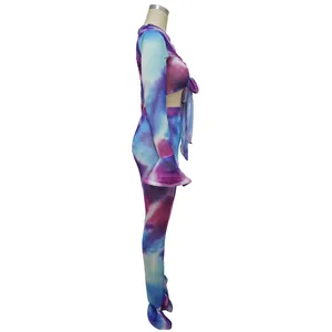 Vista laterale di completo due pezzi in mesh tie-dye viola e blu a maniche lunghe.