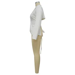 Gedetailleerd zijaanzicht van een witte slim-fit blazer met lange mouwen en strikdetail