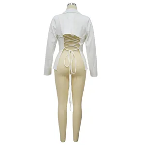 Achteraanzicht van een witte blazer met lange mouwen en een sexy vetersluiting
