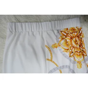 Gros plan sur la taille élastique d'un pantalon blanc avec imprimé baroque doré