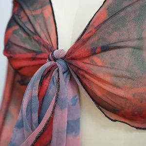 Primo piano del dettaglio del nodo su un top in rete stampata con scollo a V da donna