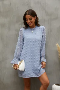 Primo piano di un abito in chiffon celeste a maniche lunghe con eleganti pois svizzeri