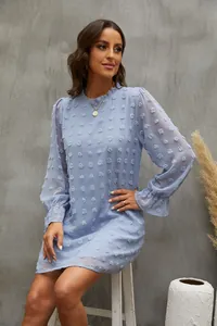 Vista dettagliata di un vestito in chiffon azzurro con eleganti maniche a sbuffo e pompon.