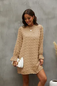Primo piano del vestito in chiffon beige con pon-pon e polsini eleganti a balze chic
