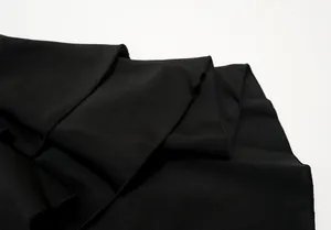 Detailed view of the black high-low fishtail skirt fabric showing fine stitching.