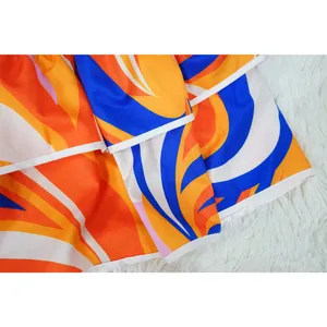 Close-up of vibrant abstract swirl print and ruffled hem of a two-piece mini skirt.