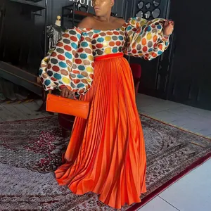 Fashionable pleated orange maxi skirt with colorful geometric print puff sleeve top