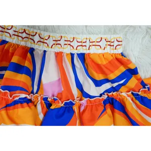 Close-up of vibrant geometric print ruffled skirt with elastic chain-pattern waistband.