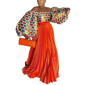 Elegant orange pleated maxi skirt paired with colorful geometric puff sleeve top