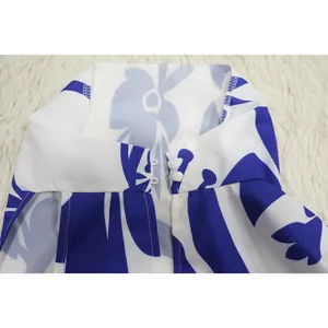 Close-up detail of white and blue floral high collar with dual white button closure