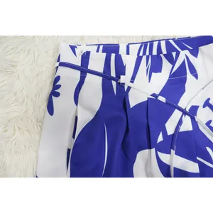 Detailed view of the waistband and belt on blue and white floral print trousers.