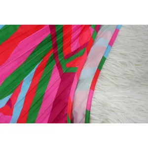 Macro view of vibrant geometric print and pleated fabric texture on summer beach dress detail