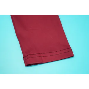 Nahaufnahme der Doppelnadelnaht an einem burgunderfarbenen Strickärmelbund