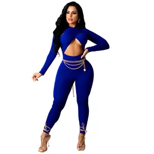 Combinaison bleue sexy à manches longues avec découpe croisée et ceinture dorée.