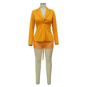 Vooraanzicht van een sexy oranje blazer-set met V-hals en korte broek op een etalagepop