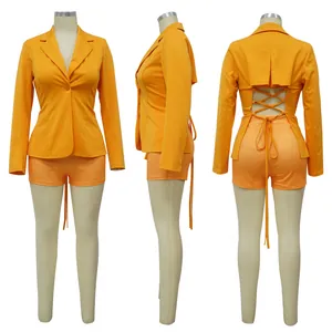 Modieus oranje tweedelig pak met blazer met vetersluiting op de rug en bijpassende shorts