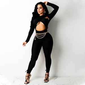 Combinaison sexy noire à manches longues avec découpe croisée et ceinture chaîne dorée