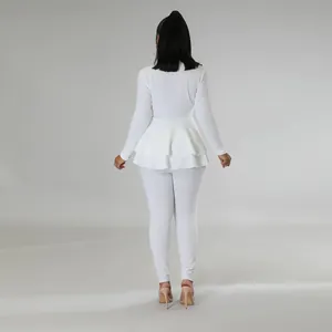 Πίσω όψη ενός κομψού λευκού σετ με μπλούζα peplum και ασορτί παντελόνι σωλήνα