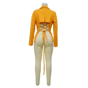 Achteraanzicht van een sexy oranje blazer met lange mouwen en een open veterrug.