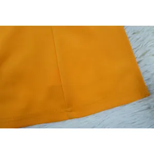 Detailweergave van de feloranje stoftextuur en de professionele dubbel gestikte zoomrand