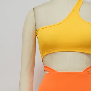 Détail rapproché du haut côtelé jaune à une épaule et de la jupe orange