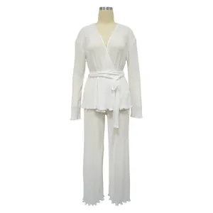 Detailed view of white pleated long-sleeve wrap top and matching wide-leg trousers set