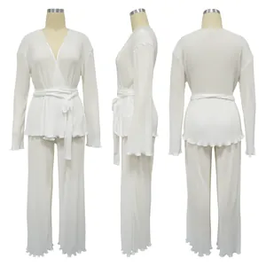 Detailed view of white pleated long-sleeve top and matching wide-leg pants set
